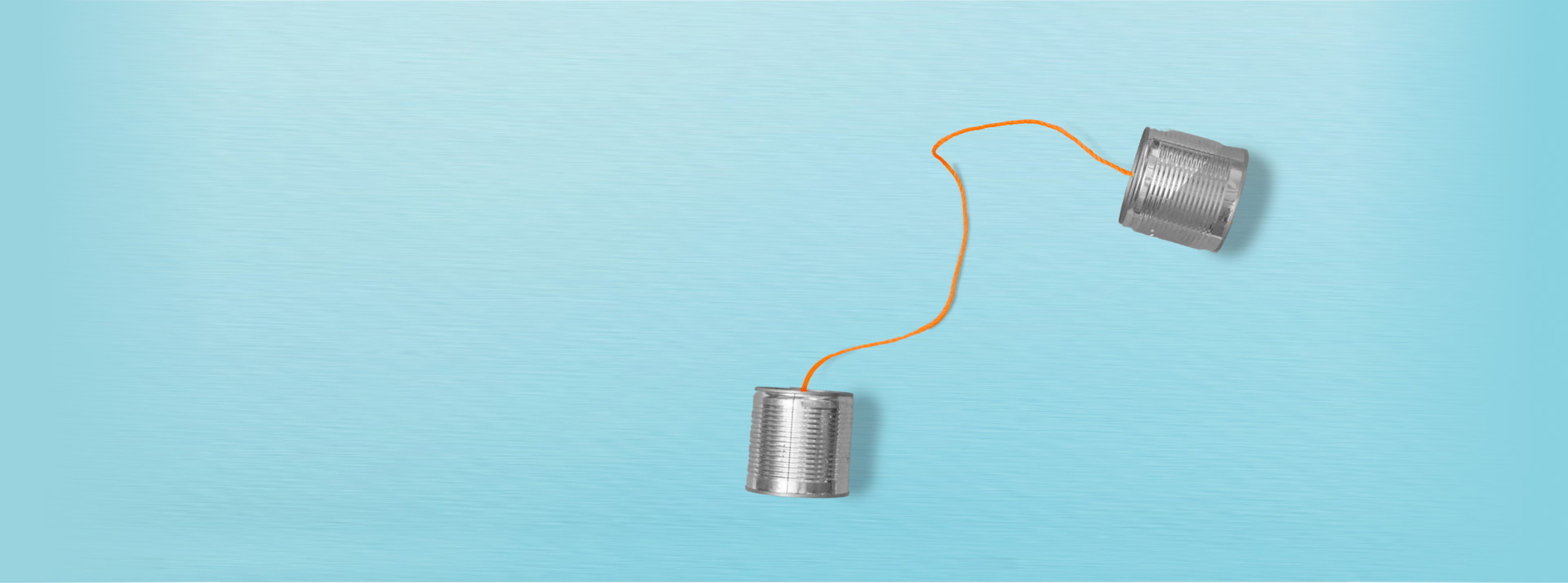 Two metal cans connected by an orange string