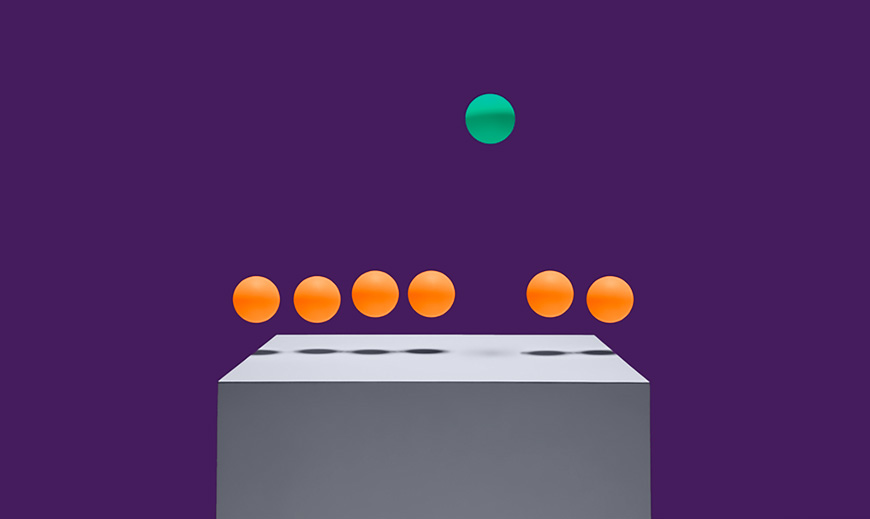 A green ball floating above six floating orange balls.
