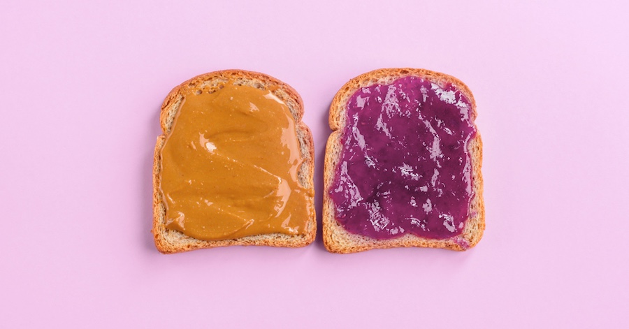 Two slices of bread with peanut butter on one slice, jelly on the other